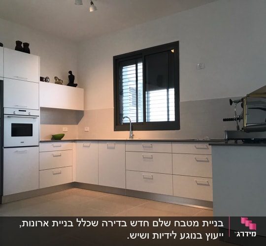 מטבח מודרני עם מקרר, תנור ומכונת קפה על השיש